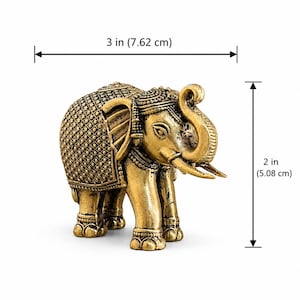 May include: A gold-colored elephant figurine with intricate embossed patterns on its back and head. The elephant has its trunk raised and tusks pointing forward. It measures 3 inches in width and 2 inches in height as indicated by the dimension lines.