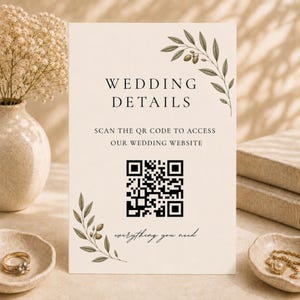 Peut inclure: Un panneau rectangulaire de détails de mariage sur papier cartonné crème avec du texte noir indiquant WEDDING DETAILS, SCAN THE QR CODE TO ACCESS OUR WEDDING WEBSITE, et everything you need, orné d'illustrations de branches d'olivier.