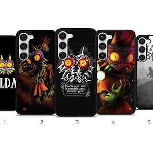 Peut inclure: Cinq coques de téléphone noires avec des motifs inspirés du jeu vidéo "The Legend of Zelda". Les coques présentent divers personnages et symboles, dont le logo du jeu, un masque et un chevalier à cheval. Chaque coque a un design différent, avec des couleurs vives.