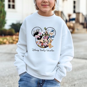 May include: A white ceramic mug with a black handle and the text "But First, Coffee" in a bold, black font. The mug is filled with a dark liquid, likely coffee, and sits on a light-colored surface.