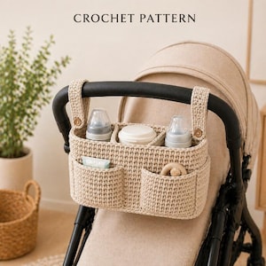 Könnte beinhalten: Ein beigefarbener Häkel-Kinderwagen-Organizer mit mehreren Fächern und Taschen. Der Organizer ist an einem schwarzen Kinderwagen-Griff befestigt und enthält Babyflaschen, einen Behälter und ein Holzspielzeug. Der Text "CROCHET PATTERN" steht oben.