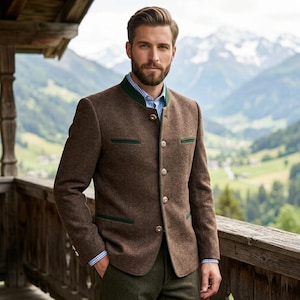 Könnte beinhalten: Eine braune Wollmischjacke mit Stehkragen, grüner Paspelierung und fünf Metallknöpfen auf der Vorderseite. Die Jacke wird über einem blau-weiß karierten Hemd getragen und mit einer dunkelgrünen Hose kombiniert.