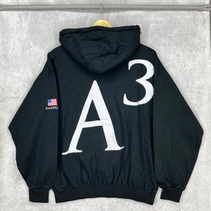 May include: A set of three ceramic mugs with a speckled, matte finish. Each mug features a different color: light blue, cream, and gray. The mugs have a simple, modern design and a comfortable handle.