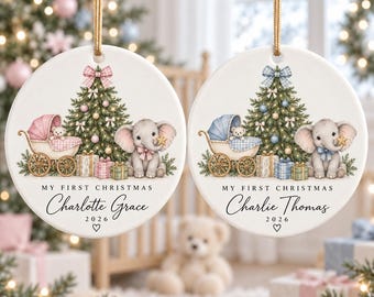 May include: Two round white ceramic ornaments with gold hanging strings. Each features a Christmas tree, a baby carriage, and an elephant holding a star. One says My First Christmas Charlotte Grace 2026, the other Charlie Thomas 2026.