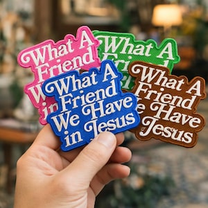 May include: A collection of embroidered patches in various colors, including pink, green, blue, and brown. Each patch features the phrase "What A Friend We Have in Jesus" in white lettering, with a decorative border.