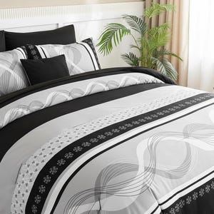 May include: A modern bed set featuring a comforter and pillows in black, gray, and white. The comforter has a striped design with wavy patterns and floral accents. The pillows are solid black and patterned.