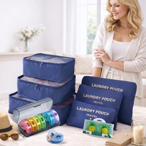 Könnte beinhalten: Eine Sammlung von Reise- und Organisationsartikeln. Enthält blaue Packwürfel, Wäschesäcke mit dem Text "Laundry Pouch Travel", einen Wochen-Pillen-Organizer und einen kleinen Behälter. Auch Sonnenbrillen und ein Strohhut sind zu sehen.