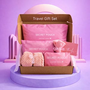 Puede incluir: Un juego de regalo de viaje en una caja de cartón abierta, con bolsas rosas, una toalla pequeña y una tarjeta de agradecimiento. Las bolsas están etiquetadas como "SECRET POUCH" con el logotipo de "Suntribe Travel". La caja está sobre una plataforma morada.