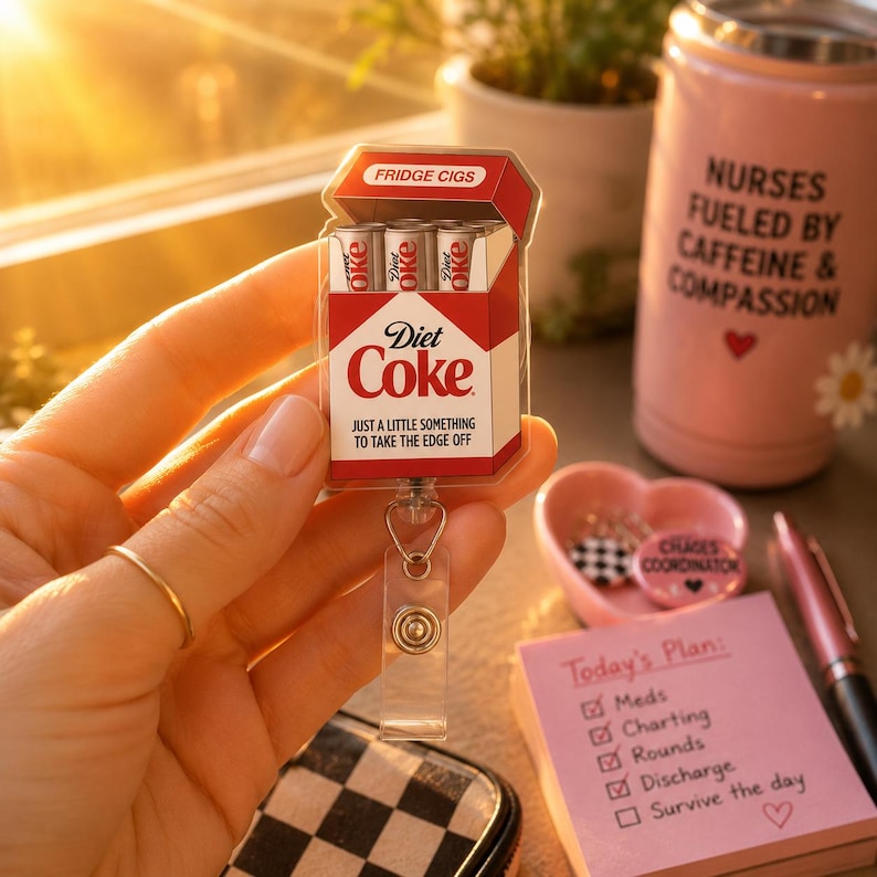 Pu&ograve; includere: Un porta badge Diet Coke con un design rosso e bianco, simile a un pacchetto di sigarette, con il testo "Diet Coke" e "Just a little something to take the edge off". Il porta badge include tre mini lattine di Diet Coke.
