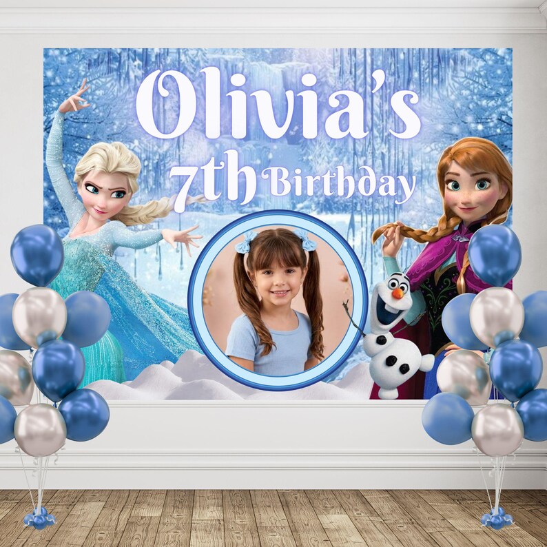 Puede incluir: Un tel&oacute;n de fondo rectangular para fiestas con Elsa, Anna y Olaf de Frozen, con el texto Olivia's 7th Birthday. Un marco circular central muestra la foto de una persona joven de pelo casta&ntilde;o. Dos ramos de globos en azul y plata flanquean el cartel.