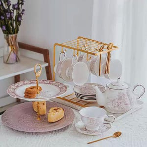 Könnte beinhalten: Ein Set aus drei Keramikbechern mit gesprenkelter, matter Oberfläche. Die Becher sind in Creme-, Hellgrau- und Dunkelgrautönen gehalten. Jeder Becher hat ein schlichtes, minimalistisches Design.