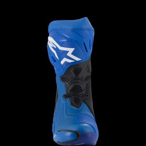 Puede incluir: Una bota de moto azul y negra con un logotipo blanco en la parte superior. La bota tiene un diseño aerodinámico con talón y puntera reforzados, y una sección perforada para ventilación. La bota está diseñada para protección y rendimiento.