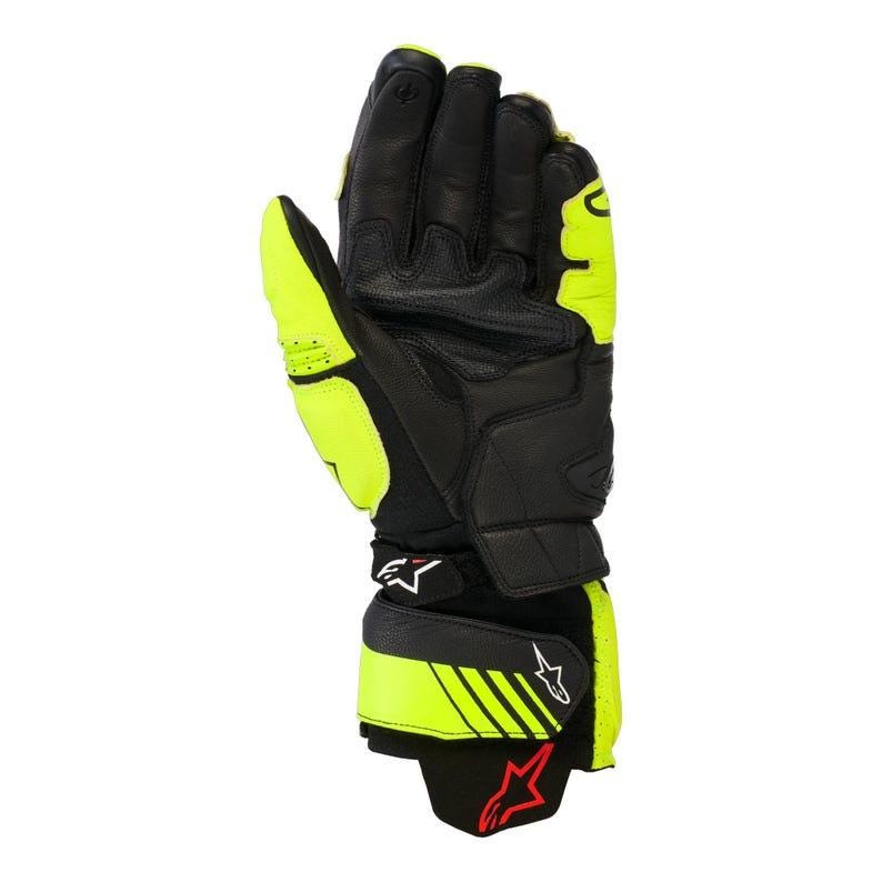 May include: Black and neon yellow motorcycle gloves. The gloves feature a leather construction with reinforced areas for protection. The design includes a prominent wrist strap with a logo and a red star. The gloves are designed for motorcycle riding.