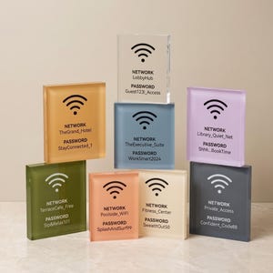 Op de afbeelding: Een verzameling van acht rechthoekige acrylborden in verschillende kleuren, elk voorzien van een zwart wifi-symbool, het woord NETWORK gevolgd door een naam en het woord PASSWORD gevolgd door een unieke code, gerangschikt in een stapel.