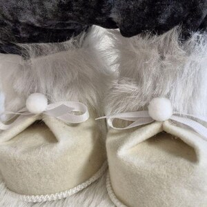 May include: A white ceramic mug with a black handle and the text "But First, Coffee" in a bold, black font. The mug is set against a neutral background, highlighting its simple design.