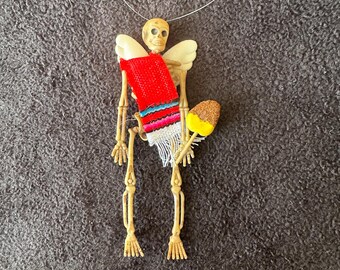 Red Sarape day of the dead skeleton ornament with wings and a mango #06