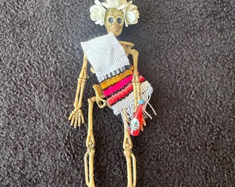 White Sarape day of the dead skeleton ornament with a flower crown and soda