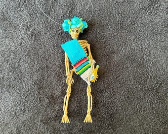 Turquoise Sarape day of the dead skeleton ornament with a flower crown and soda #04