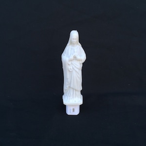 Könnte beinhalten: Weißes Nachtlicht aus Kunststoff in Form einer Statue der Jungfrau Maria. Die Statue steht mit gefalteten Händen im Gebet.
