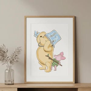 May include: A framed print featuring a cartoon illustration of Winnie the Pooh and Piglet. Pooh is holding a blue bucket, and Piglet is carrying a stick. The artwork has a soft color palette and is displayed on a wooden surface.