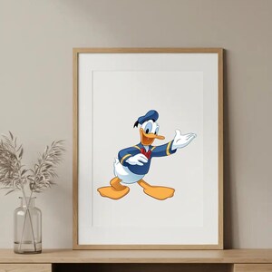 Puede incluir: Impresi&oacute;n enmarcada con una ilustraci&oacute;n de dibujos animados de Pato Donald. El personaje lleva su traje de marinero, con chaqueta y gorro azules y pajarita roja. La obra de arte est&aacute; sobre un fondo blanco dentro de un marco de madera.