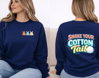 May include: Navy blue sweatshirt with a small embroidered bunny design on the front and the text "Shake Your Cotton Tail" on the back. The back design includes a fluffy white cotton tail. The sweatshirt is worn with blue jeans.