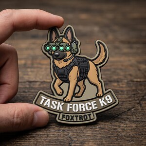 May include: A tan and black German Shepherd dog patch wearing a black tactical vest and green night vision goggles. The patch features the text TASK FORCE K9 and FOXTROT in white lettering on a tan background with a black border outline.