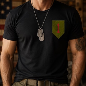 May include: Black t-shirt with a green and red patch on the chest. The patch features a red number "1" on a green background. The shirt is worn with a silver dog tag necklace.