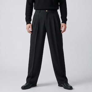 Pu&ograve; includere: Pantaloni neri a pieghe con chiusura a bottone e design a gamba larga. I pantaloni sono abbinati a un maglione nero e scarpe in pelle nere. I pantaloni hanno un look classico e su misura.