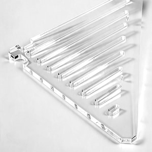Könnte beinhalten: Transparenter Acryl-Präsentationsständer in Dreiecksform mit mehreren horizontalen Ablagen. Der Ständer dient zur Präsentation von Artikeln. Die Kanten sind glatt und das Design minimalistisch.