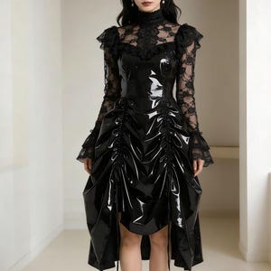 May include: A black, high-collared dress with a glossy, patent leather-like bodice and a lace overlay on the sleeves and shoulders. The skirt features gathered detailing and a high-low hemline. The dress has a gothic or Victorian aesthetic.