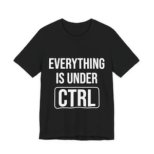Op de afbeelding: Zwart T-shirt met de witte tekst "EVERYTHING IS UNDER CTRL". De tekst staat in het midden op de voorkant van het shirt. Het woord "CTRL" staat in een witte rechthoek.