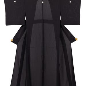 May include: A black kimono with wide sleeves and a flowing skirt. The garment has gold accents on the sleeves and is hanging against a white background. The kimono is made of a sheer fabric.