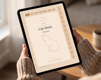 May include: A digital tablet displaying a Cat Mom Planner interface with a beige background, a line-art cat illustration, and navigation tabs along the side. The screen features text including Cat Mom Planner and various section labels.