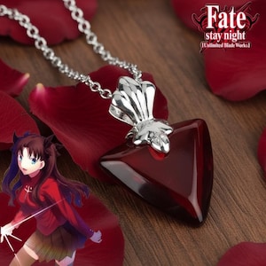 Può includere: Collana d'argento con un ciondolo triangolare rosso scuro. Il ciondolo ha una parte superiore decorativa argentata. Lo sfondo include petali di rosa rossi e il testo "Fate stay night [Unlimited Blade Works]"