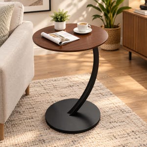 May include: A round side table with a dark brown wood-grain top and a black metal base. The table features a curved, C-shaped support column connecting the circular tabletop to a flat, circular base, providing a stable structure.