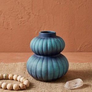 Puede incluir: Un juego de tres tazas de cerámica con un acabado mate moteado. Las tazas son de color crema, gris claro y gris oscuro. Cada taza tiene un diseño simple y minimalista, ideal para café o té.
