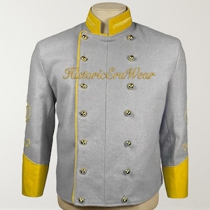 Può includere: Una giacca doppiopetto grigio chiaro con colletto alto giallo, polsini gialli e bottoni color oro. La giacca presenta un profilo giallo lungo la chiusura anteriore e la scritta HistoricEraWear ricamata in oro sulla zona del petto.