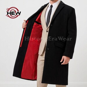 Peut inclure: Un long manteau noir avec une doublure rouge. Le manteau est boutonné et porté sur un costume beige, une chemise blanche et une cravate noire. Le manteau a un design classique et élégant.