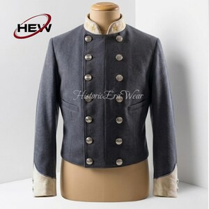 May include: A charcoal gray military-style jacket featuring a double-breasted front with two columns of silver-toned buttons, a high cream-colored collar with embroidered gold stars, and cream-colored cuffs. The text HEW and Historic Era Wear appear.