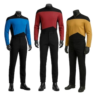 Può includere: Tre uniformi complete su manichini. Quella a sinistra presenta un top blu con dettagli neri, quella centrale un top rosso con dettagli neri e quella a destra un top dorato con dettagli neri. Tutte includono pantaloni, guanti e stivali neri.