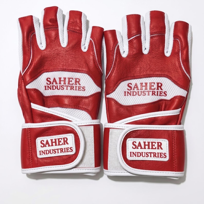 May include: A pair of red and white fingerless gloves featuring white mesh panels and red leather sections. The text SAHER INDUSTRIES is printed in red on the white mesh and on a white rectangular patch on the adjustable wrist strap of each glove.