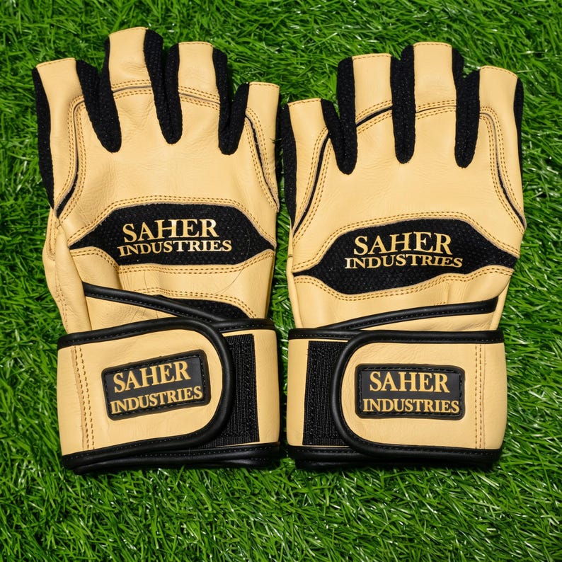 May include: A pair of fingerless gloves in tan and black. The gloves feature black mesh panels, tan leather sections, and adjustable wrist straps with hook-and-loop closures. The text SAHER INDUSTRIES is printed in gold on the back and wrist strap.