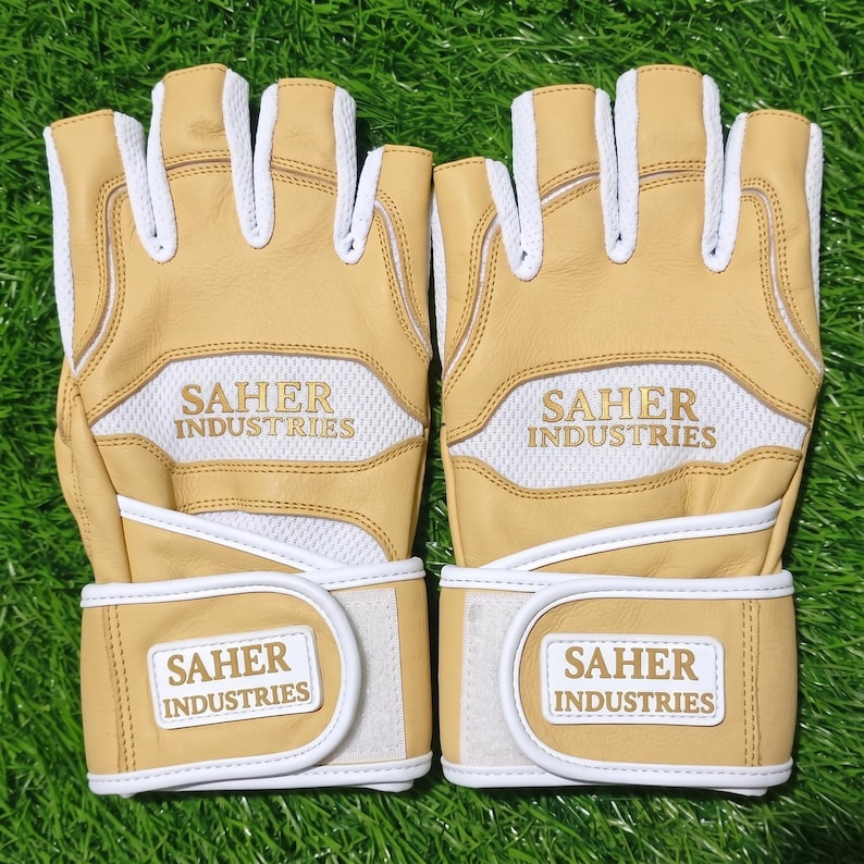 May include: A pair of fingerless gloves in tan and white. The gloves feature tan leather panels, white mesh inserts, and white piping. The text SAHER INDUSTRIES is printed in gold on the back of the hand and on the white wrist strap closure.