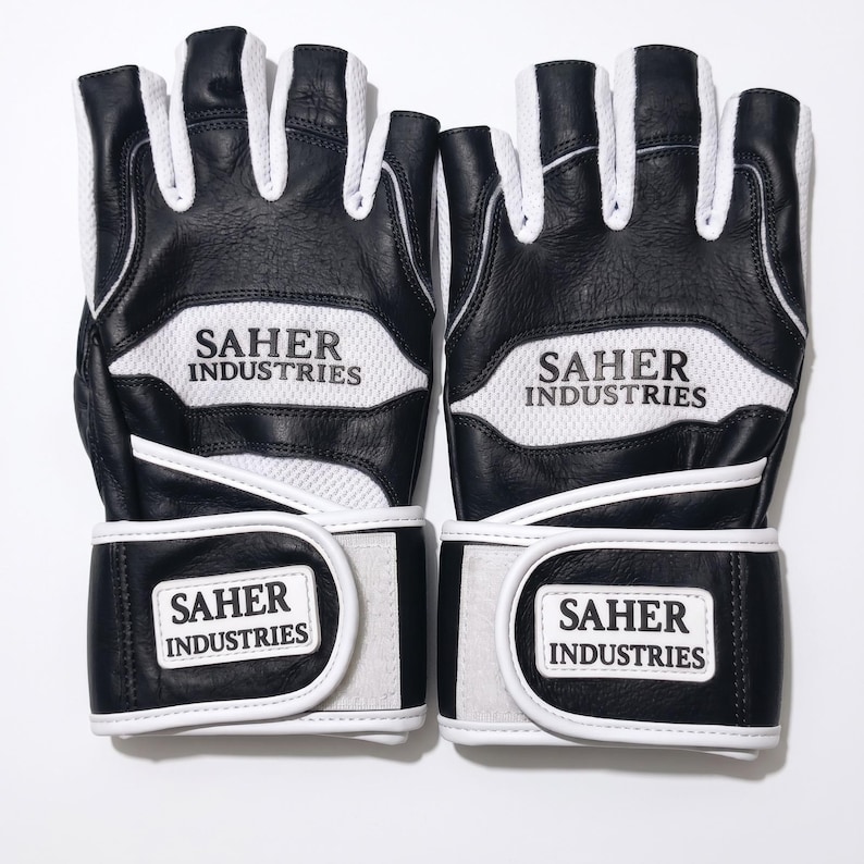 May include: A pair of black and white fingerless gloves featuring a textured leather construction with white mesh panels. The text SAHER INDUSTRIES is printed in black on the white mesh and on the white rectangular hook-and-loop wrist straps.