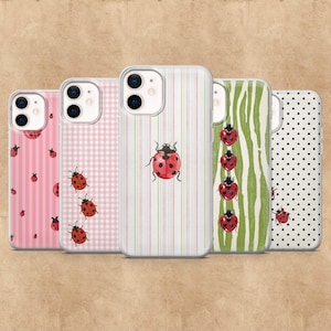 May include: Five phone cases with ladybug designs. The cases feature various patterns, including pink stripes, a pink gingham check, white stripes, green zebra stripes, and black polka dots. Each case has a clear border.