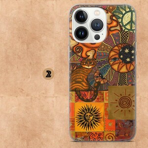 May include: A colorful phone case featuring a patchwork design with a cat, sun, moon, and peace sign. The case has a clear border and a vibrant, artistic aesthetic. The cat is orange and brown, and the sun has a face.