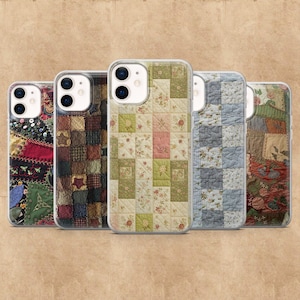 May include: Five clear phone cases with patchwork quilt designs. The cases feature various patterns, including floral, plaid, and geometric squares in shades of red, green, brown, and blue. The cases are displayed against a brown background.