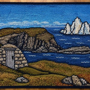 May include: A rectangular rug featuring a textured, hooked-yarn landscape scene. The image depicts a stone structure with a door, grassy hills in shades of brown and green, a deep blue ocean, and a cluster of white, jagged icebergs in the distance.