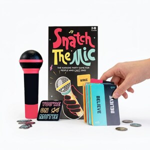 May include: A karaoke party game called "Snatch The Mic" with a black and pink microphone prop, game cards, and game tokens. The game box features the game title and a microphone illustration. The game is for 2-10 players.